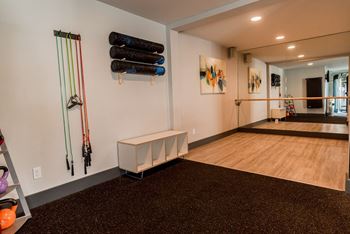 a fitness room with a treadmill and weights on the wall